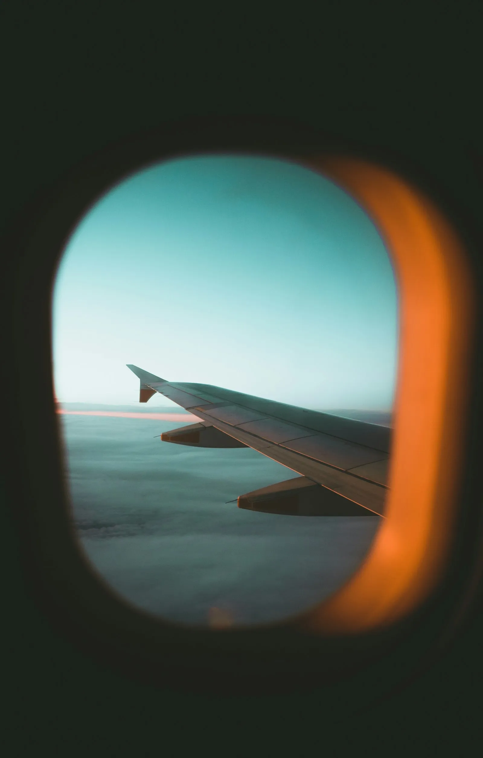Ala de avión vista a través de la ventanilla al atardecer